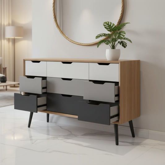 A mid-century modern 6-drawer dresser with a light wood top and frame, white, gray, and dark gray drawer fronts, and black tapered legs, shown in a bedroom setting.