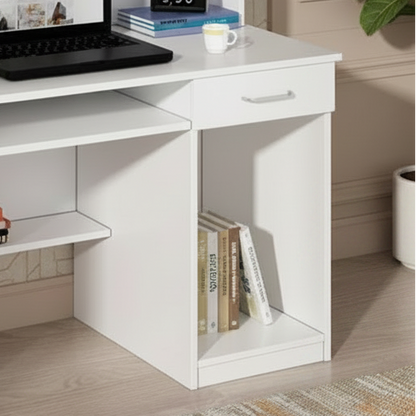 White desk with a laptop, books, and a plant in a room with patterned wallpaper.
