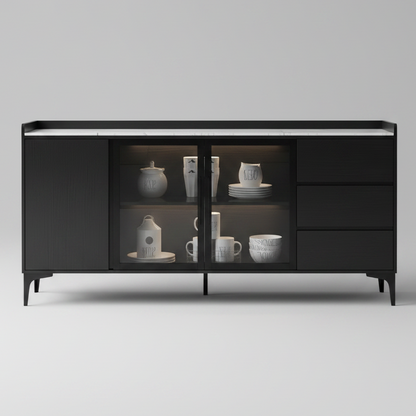 A modern black sideboard cabinet with glass doors and drawers, styled in a contemporary living room setting with a marble-look top and decorative items.