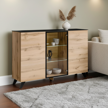 A modern wooden sideboard cabinet with a black top and legs, featuring two wood-grain doors and a central glass display cabinet. It is styled in a living room setting next to a sofa on a gray rug.