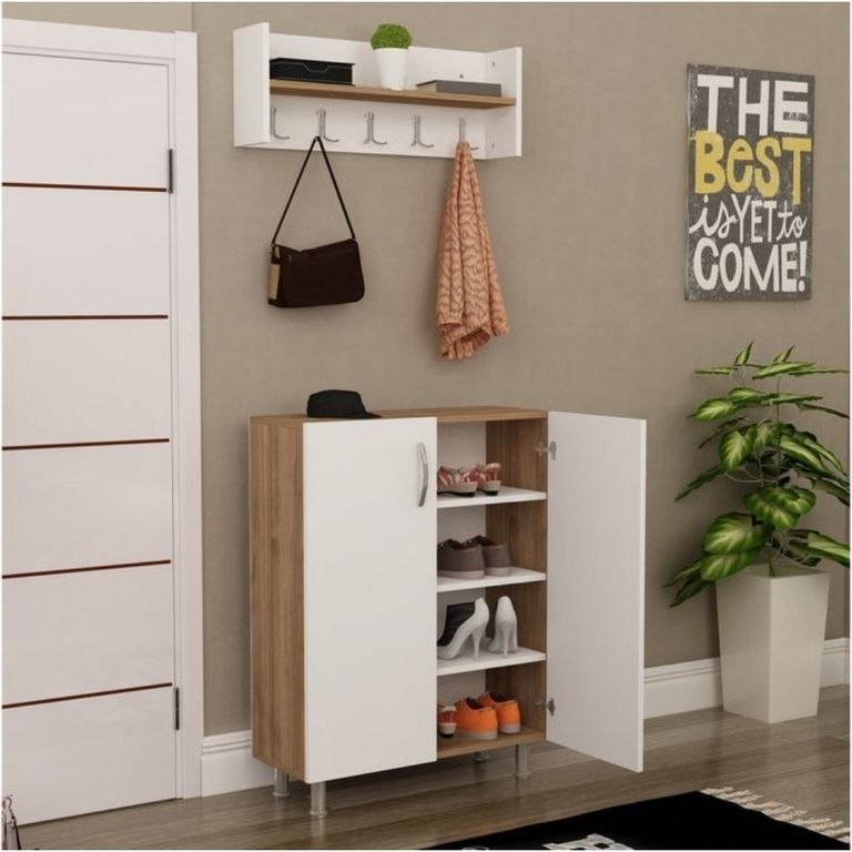 A white and light wood entryway shoe cabinet with open doors, shown in a styled room with a wall-mounted hook rack, hanging bag, scarf, shoes on shelves, a door, wall decor, and a potted plant.