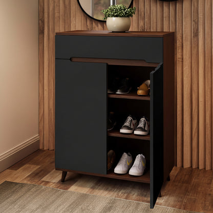 A modern shoe cabinet with a dark charcoal gray front and a medium brown wood-grain finish, shown with one door open to reveal shelves with shoes. The cabinet is set against a wooden slatted wall and wood floor, with a potted plant on top.